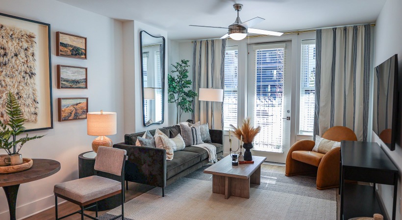 a living room with a green couch and large window