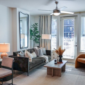A living room with a green couch and large window